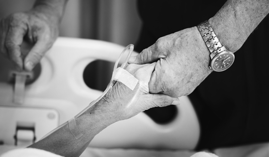 A person holding an elderly patient's hand