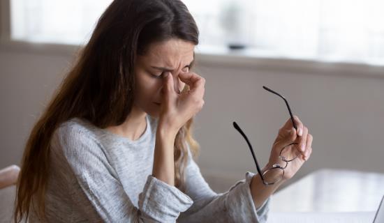 fatigued woman holds glasses