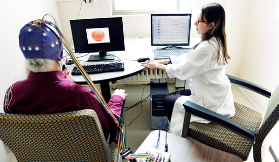 A senior man sitting in a lab chair with a research and brain activity technologies