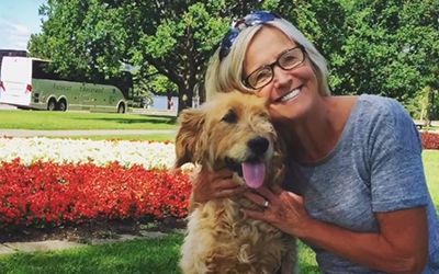 Crystal and her dog by a bed of tulips